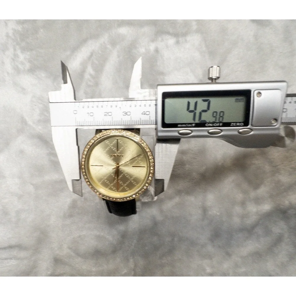 DKNY 111007 Gold Tone All Over Logo Womens 43mm Wristwatch Gem Set Bezel
